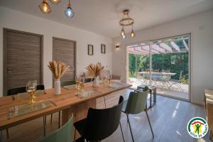Montclar-sur-GervanneにあるGîte Le Chaudron 1 à 7pers avec piscineの大きな木製のテーブルと椅子のあるダイニングルーム