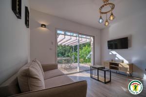 Montclar-sur-GervanneにあるGîte Le Chaudron 1 à 7pers avec piscineのソファとテレビのあるリビングルーム