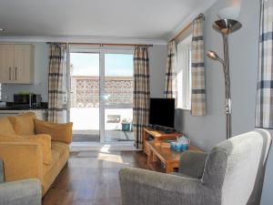 a living room with a couch and chairs and a tv at 4 West Park Mews in Kingsbridge