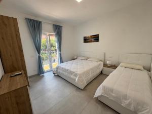 a bedroom with two beds and a sliding glass door at Home & Garden in Vico Equense