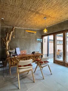 a wooden table with two chairs and a laptop on it at Lodge Don Julio in San Pedro de Atacama +50 photos
