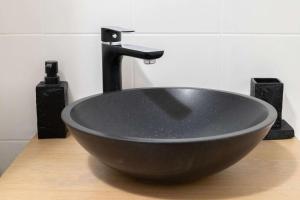 a black bowl sink sitting on a wooden counter at Studio JadOr gare RER B Le Bourget - Paris aeroport Charles de Gaulle in Le Bourget