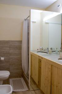a bathroom with a sink and a toilet and a mirror at Terra della Luna casa vacanze in Nicola