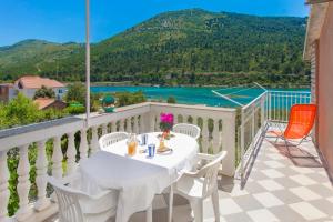 una mesa en un balcón con vistas al agua en Apartmani Maestral, en Grebaštica