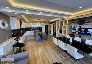 a large kitchen with white chairs and a counter at selimpiya villaları in Silivri