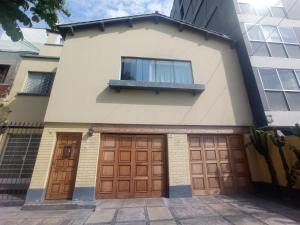 a house with two garage doors and a window at Gutierrez Hostel in Lima