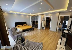 a bedroom with a bed and a living room with chairs at selimpiya villaları in Silivri