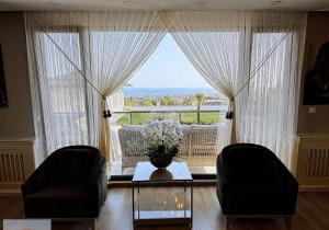 a living room with a table and chairs and a large window at selimpiya villaları in Silivri