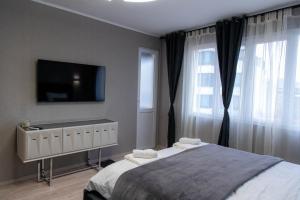 ein Schlafzimmer mit Bett und Flachbildfernseher in der Unterkunft Golden Light - 3BR Luxury Central in Bŭnzareto