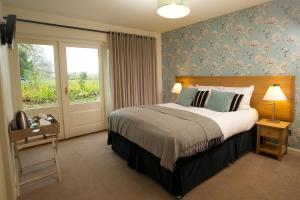 Un dormitorio con una cama grande y una ventana en The Marquess of Exeter, en Uppingham