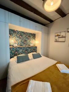 a bedroom with a large bed with a painting on the wall at La Porte Chartraine - Appartement avec terrasse au coeur de Blois in Blois +9 photos
