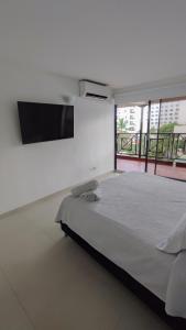 Un dormitorio con una cama grande y un televisor de pantalla plana. en En el edificio Hansa Reef - Apartamento Premier 6, en San Andrés