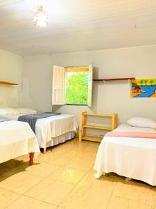 a bedroom with two beds and a window at Casa de Praia Caminho das Indias in Coroa Vermelha