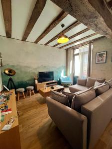 a living room with a couch and a table at La Porte Chartraine - Appartement avec terrasse au coeur de Blois in Blois