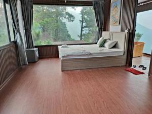 a bedroom with a bed and a large window at Mimosa 228-phòng săn mây in Tam Ðảo