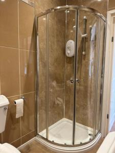 a shower with a glass door in a bathroom at The Calder House Hotel in Seascale