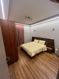 ein Schlafzimmer mit einem Bett und einem Holzboden in der Unterkunft Madinaty Stunning Villa in Madinaty + 4 Fotos