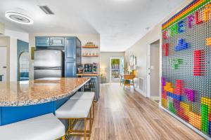 a kitchen with blue cabinets and a colorful tile wall at Lite Brite Beach Escape - Shine Brite, Relax Right! in Seminole