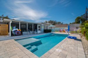 a swimming pool in front of a house at Lite Brite Beach Escape - Shine Brite, Relax Right! in Seminole