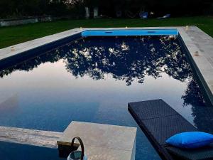 a swimming pool with a tree reflection in the water at Séjour ressourçant en Berry proche Zoo de Beauval - FR-1-591-732 in Saint-Cyran-du-Jambot