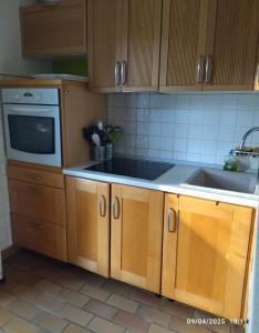 a kitchen with wooden cabinets and a sink at Calme, familiale ,charmante in Castries