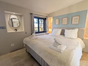 a bedroom with a large bed with towels on it at Séjour Historique au Domaine de Migny : Gîte avec Bain Nordique et Piscine - FR-1-591-731 in Saint-Cyran-du-Jambot
