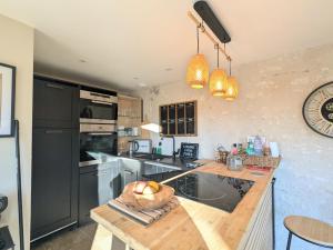 a kitchen with a counter with a bowl of fruit on it at Séjour Historique au Domaine de Migny : Gîte avec Bain Nordique et Piscine - FR-1-591-731 in Saint-Cyran-du-Jambot