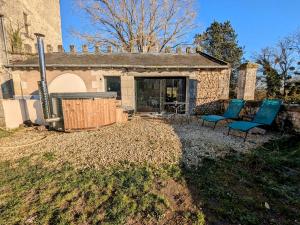 a house with two blue chairs in the yard at Séjour Historique au Domaine de Migny : Gîte avec Bain Nordique et Piscine - FR-1-591-731 in Saint-Cyran-du-Jambot