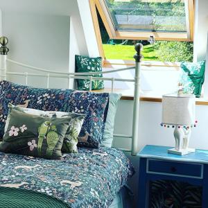 a bedroom with a bed and a table with a lamp at Luxury Three Bedroom Barn Conversion in Devon in Hemyock