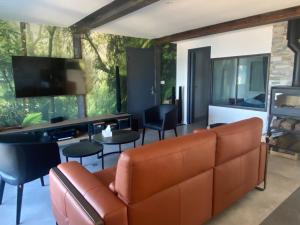 a living room with a couch and chairs and a television at Beach house Maison de plage les pieds dans l eau in Plérin