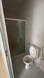 a bathroom with a toilet and a glass shower at Apartamento Centro de Tauá in Tauá