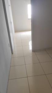 an empty room with a white floor and an open door at Apartamento Centro de Tauá in Tauá