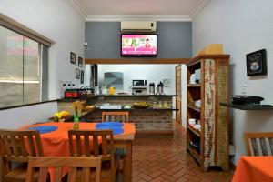 a kitchen and dining room with a table and a television at Ribeirão Plaza Hotel in Ribeirão Preto