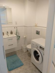 a bathroom with a washing machine and a toilet at Meta nad morzem in Pogórze