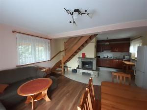 a living room with a couch and a table and a kitchen at Domek Pod Jawornikiem in Wetlina