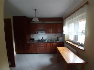 a kitchen with wooden cabinets and a wooden table at Domek Pod Jawornikiem in Wetlina +13 photos