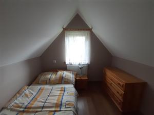 a attic bedroom with two beds and a window at Domek Pod Jawornikiem in Wetlina