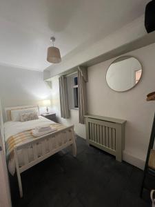 a bedroom with a bed and a large mirror at Campbell's Cottage in Blackwatertown