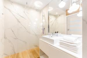 ein Badezimmer mit einem weißen Waschbecken und einem Spiegel in der Unterkunft APT Nadmorskie - Bliżej Morza in Kołobrzeg + 72 Fotos