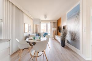 eine Küche und ein Wohnzimmer mit Tisch und Stühlen in der Unterkunft APT Nadmorskie - Bliżej Morza in Kołobrzeg