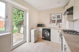 a kitchen with a washer and dryer in it at Barnet newly renovated in Barnet