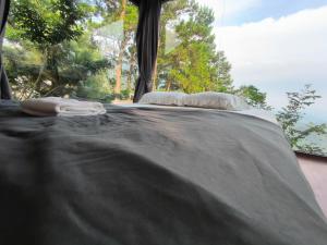 a bed with two pillows on it with a window at Mimosa 226 - phòng săn mây in Tam Ðảo