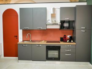 una cucina con mobili grigi e un lavandino di SaraHome a Bari Altre 8 foto
