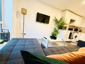 a living room with a couch and a tv at Spacious 2 Bed Flat Free Private Parking in Leeds