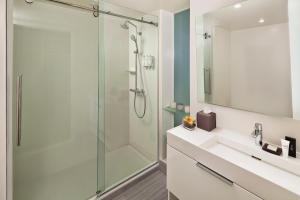 a bathroom with a shower, sink, and tub at INNSIDE by Melià New York Nomad in New York