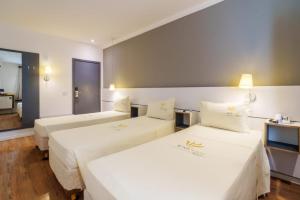 Postel nebo postele na pokoji v ubytování Uniclass Hotel Pinheiros