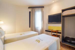 Postel nebo postele na pokoji v ubytování Uniclass Hotel Pinheiros