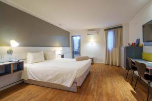 Postel nebo postele na pokoji v ubytování Uniclass Hotel Pinheiros