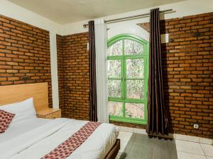 a bedroom with a bed and a brick wall at Hotel Saint jean Leopold Apartment in Kigali