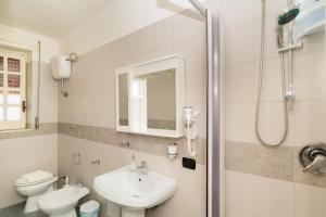 a bathroom with a sink and a toilet and a shower at Hotel sul Mare e Lido Atena in Paestum